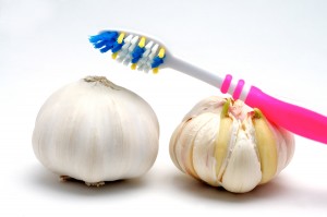 Toothbrush and garlic on a white background