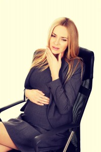 Pregnant woman in the office suffering from tooth pain