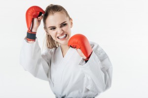 female karate fighter training with gloves and mouthguard isolated on white