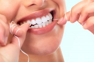 Close-up view of a woman flossing her teeth. 