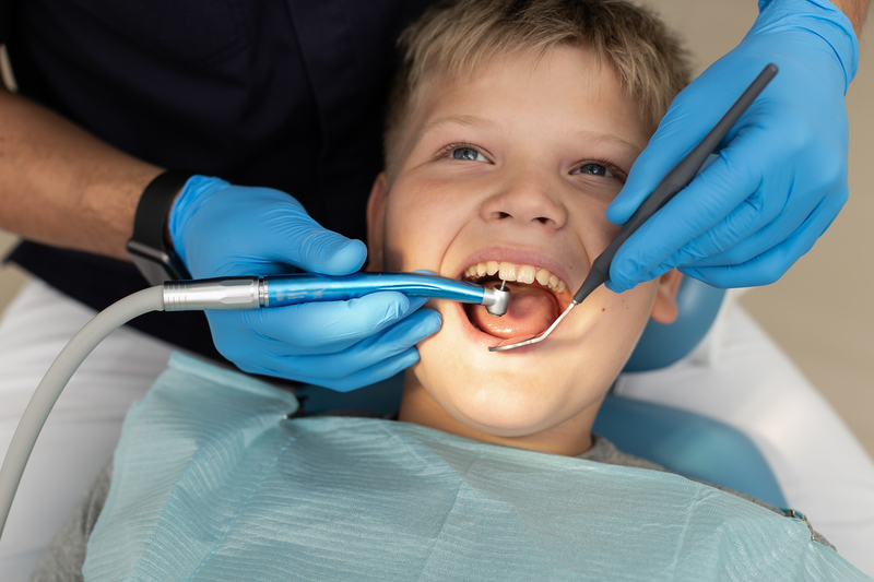 Young boy having his teeth cleaned at the dentist office.