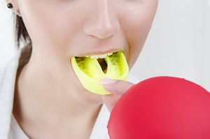 Young boxing woman using mouthguard