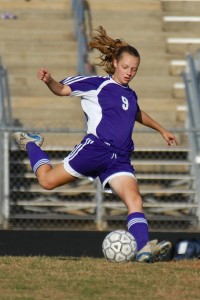 Female soccer player taking a shot on goal