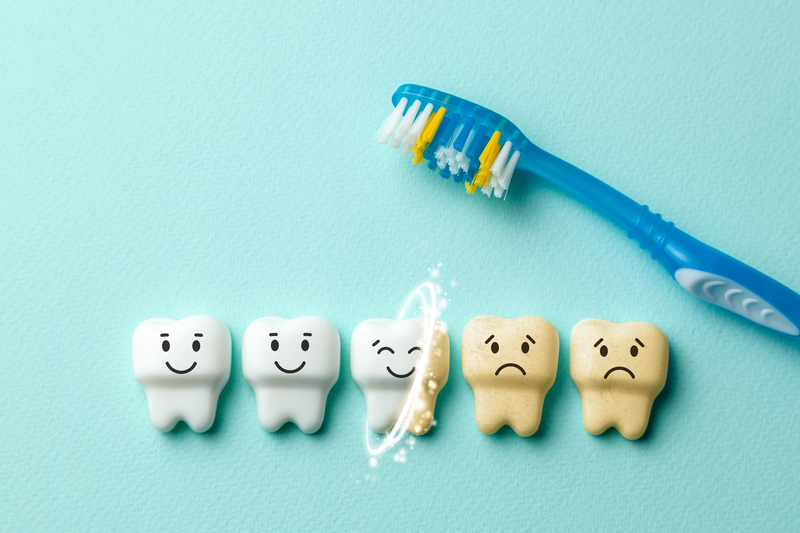 Animation of three healthy teeth and two dirty teeth with a toothbrush sitting nearby.
